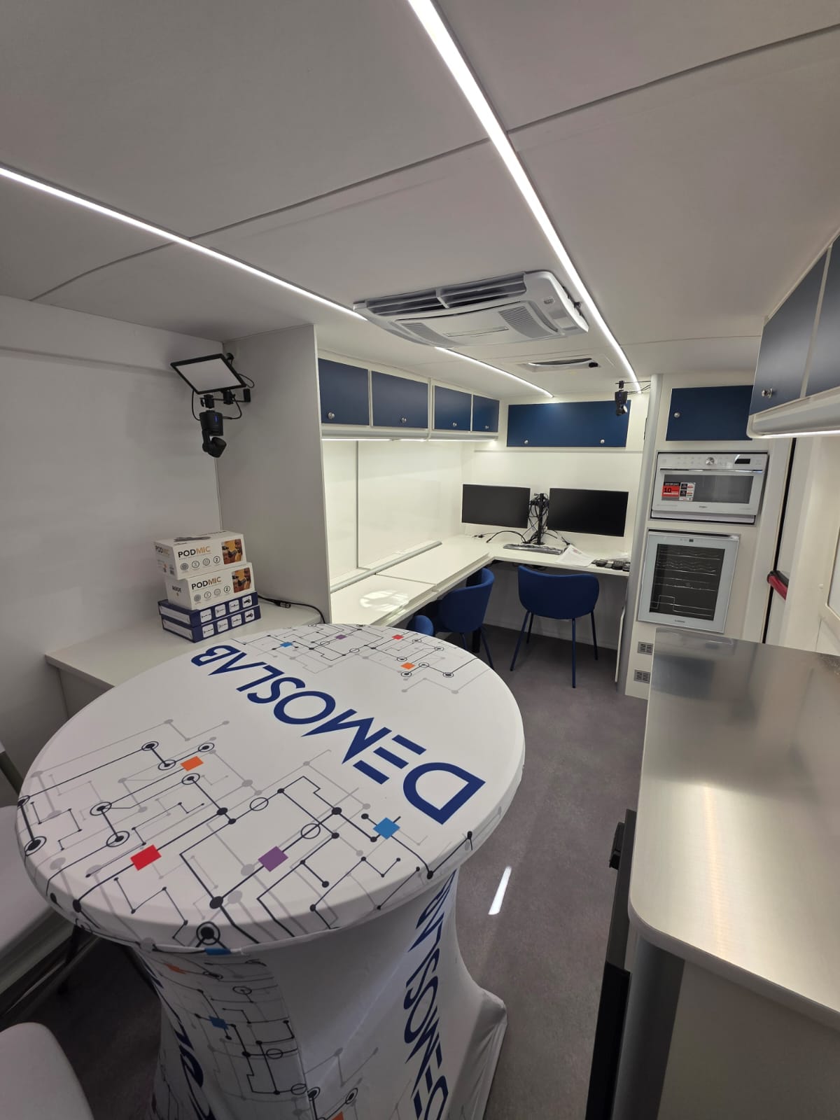 Interno del DEMOS Lab mobile con postazioni di lavoro e tavolo centrale
