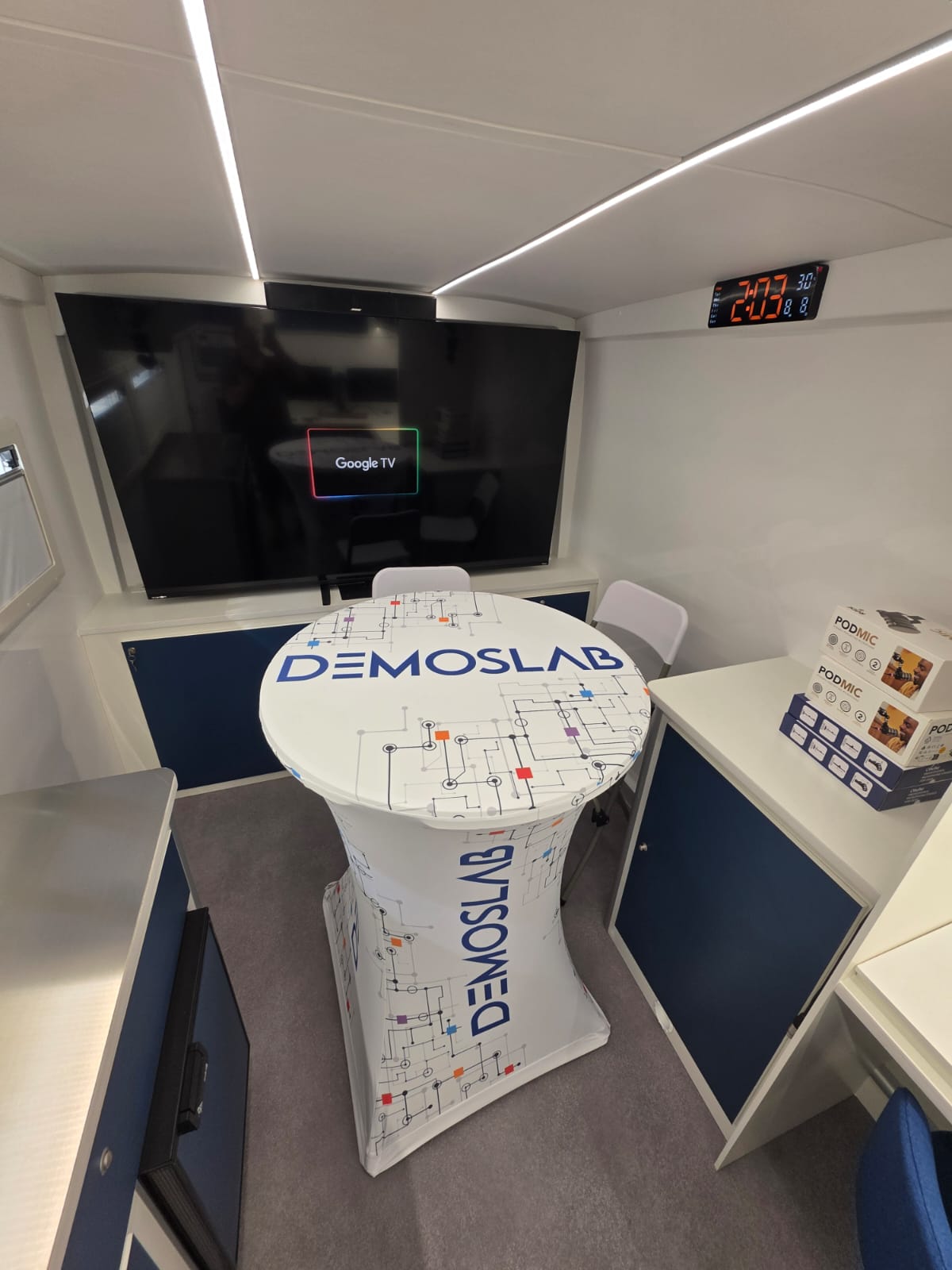 Area interna del DEMOS Lab mobile con grande schermo e tavolo centrale